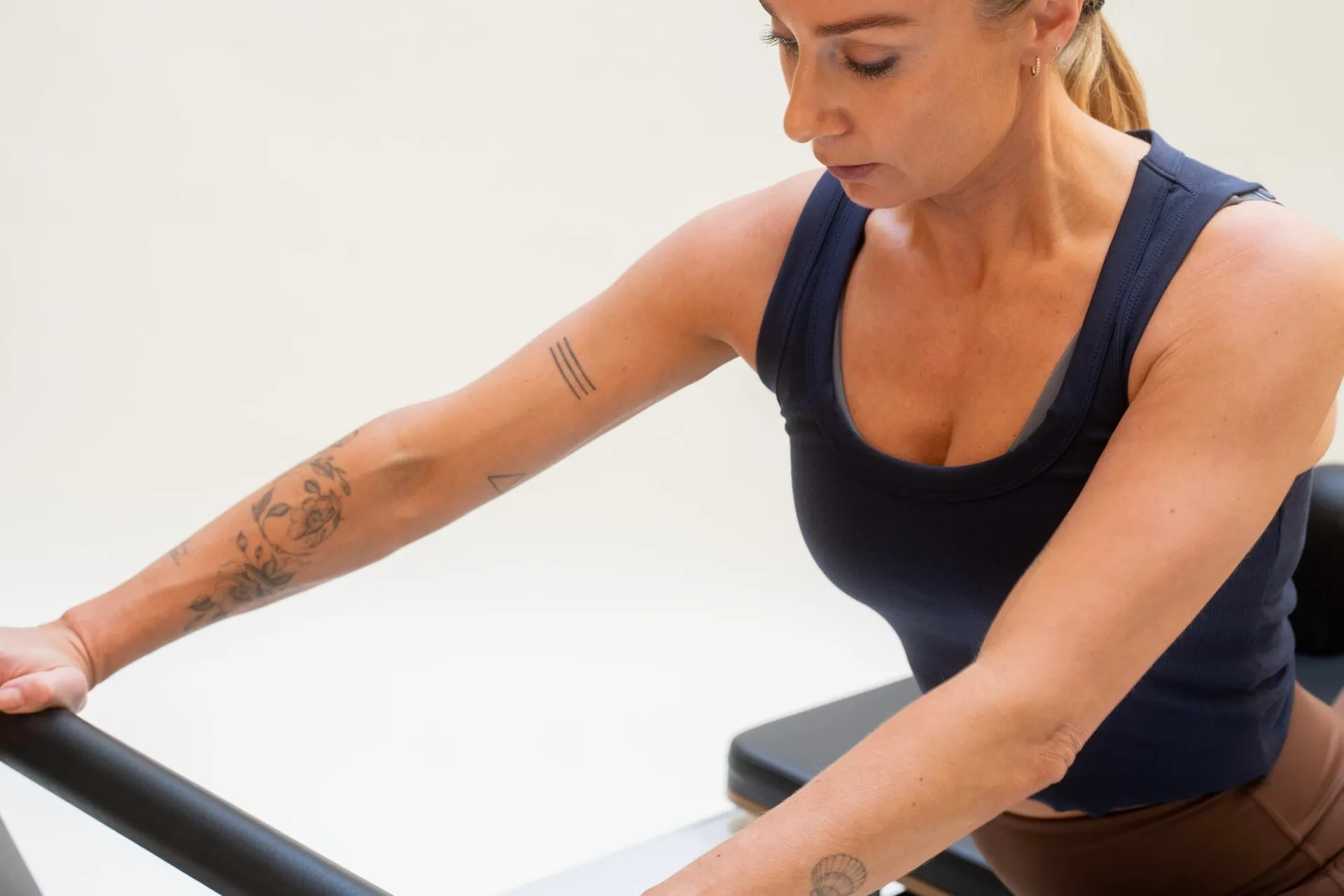 Pilatesinstruktør veileder student på reformer